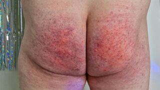 Domina Nika beats slave's naked rear until it reddens Femdom BDSM spanking