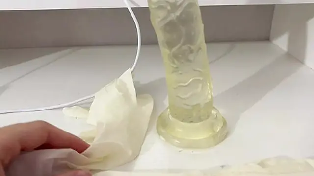 I rub my oily hands over the dildo in medical gloves